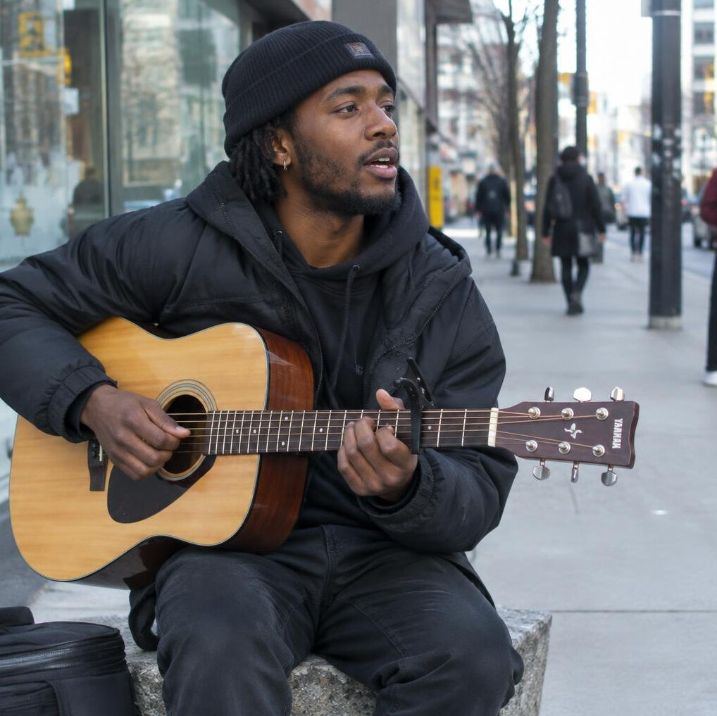 Street musician performing on a city sidewalk
